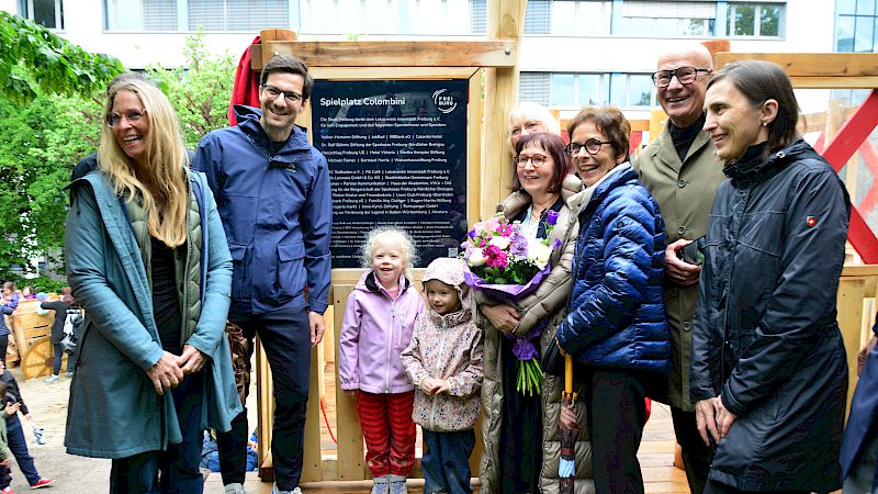 Kinder und Gäste vor der Spendentafel des Colombini-Spielplatzes